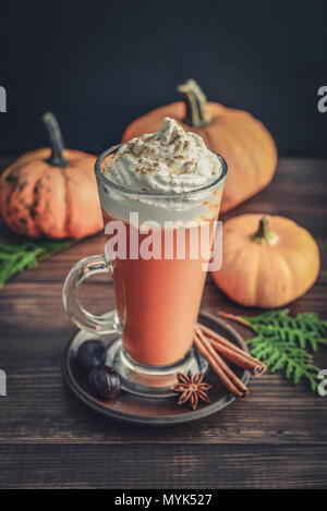 Pumpkin spice Latte mit Schlagsahne auf hölzernen Hintergrund Stockfoto