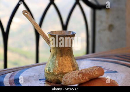 Ein libanesischer Kaffeekanne aus Messing und begleitenden traditionellen Süßigkeiten maamoul genannt. Stockfoto