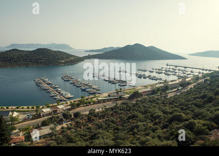 Ein Panoramablick auf einen luxuriösen Yachthafen in einer ruhigen Bucht, mit Segelbooten und Yachten im Wasser, umgeben von üppigen Hügeln und ruhigen Inseln, Stockfoto