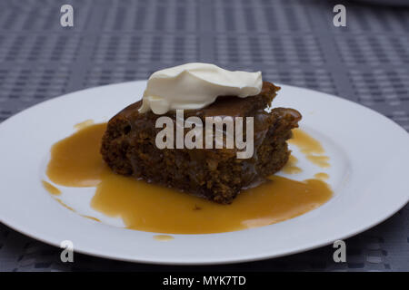 Sticky date Pudding mit Karamellsauce garniert mit Sahne Stockfoto