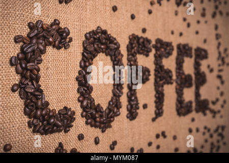 Kaffee Wort mit gerösteten Kaffeebohnen auf Draufsicht Zusammensetzung geschrieben Stockfoto