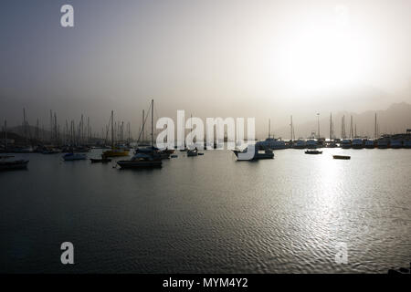 MINDELO, KAP VERDE - Dezember 07, 2015: Boote und Yachten im Hafen der Insel Sao Vicente im hellen Licht der misty Sonnenuntergang Stockfoto