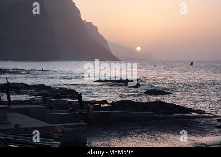 PONTA DO SOL, KAP VERDE - Dezember 08, 2015: Sonnenuntergang abends an der felsigen Küste von Santo Antao Insel. Menschen zu Fuß und beobachten die Sonne, Stockfoto