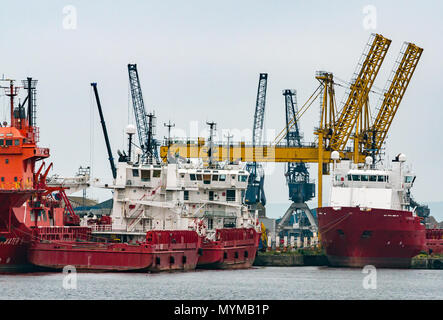 Versorgungsschiffe angedockt in Eingang Becken, Leith Harbour, Edinburgh, Schottland, Großbritannien mit Tower crane und Krane Stockfoto