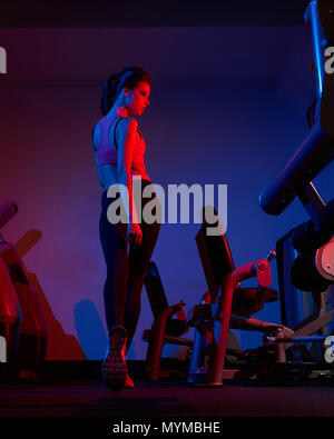 Weibliche fitness Modell gehen zwischen zwei Reihen von Übung Machin Stockfoto