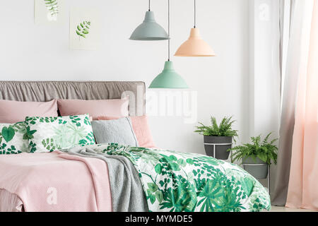 Drei Lampen in Pastelltönen hängen über dem Bett mit weichen bedhead in hellen Innenraum Stockfoto