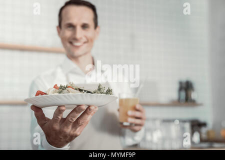Foto fokussiert auf die männliche Hand, dass Salat Stockfoto