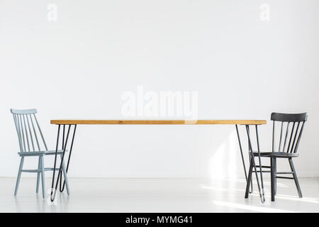 Kopieren von weißen Raum mit zwei klassischen Stühle an einem langen Holztisch Stockfoto