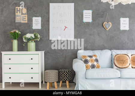 Zimmer mit Wand Dekorationen Kommode, Sofa und Polsterhocker Stockfoto