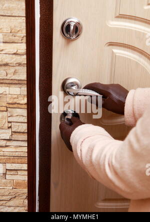 Eine Frau in einem Fell und Leder Handschuhe öffnet die Tür von innen. Stockfoto