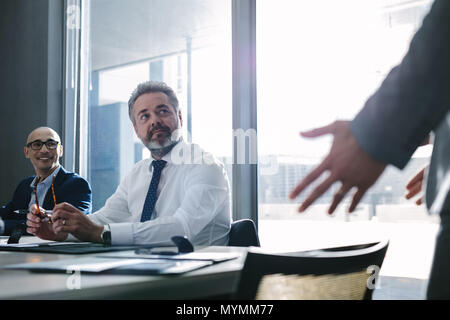 Senior im Büro hören Manager während der Sitzung im Konferenzraum. Geschäftsmann während der Sitzung im Büro. Stockfoto