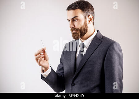 Verwirrter Geschäftsmann auf Zigarette in der Hand. Stockfoto