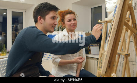 Künstlerin Unterrichten junger Student mit Aquarell zu malen Stockfoto