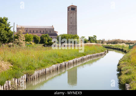 Basilica di Santa Maria Assunta bei Sonnenaufgang, Torcello, Insel, Venedig, Venetien, Italien mit dem Glockenturm oder Campanile in den Kanal wider. Malerische lan Stockfoto