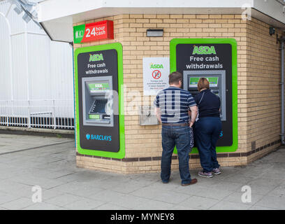 Ein paar Verwendung einer ATM Geldautomaten außerhalb Asda in Thornaby, England, Großbritannien Stockfoto