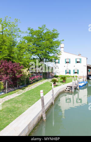 Ristorante Villa 600 (Villa 600 Restaurant), Torcello, Insel, Venedig, Venetien, Italien mit Reflexionen in den Kanal an einem sonnigen Frühlingstag Stockfoto