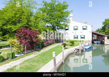 Ristorante Villa 600 (Villa 600 Restaurant), Torcello, Insel, Venedig, Venetien, Italien mit Reflexionen in den Kanal an einem sonnigen Frühlingstag Stockfoto