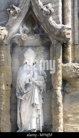 Stone Carving (von einem Mann mit einem Buch und einem Leiter) auf einer Außenwand am Magdalen College der Universität Oxford, England. Stockfoto