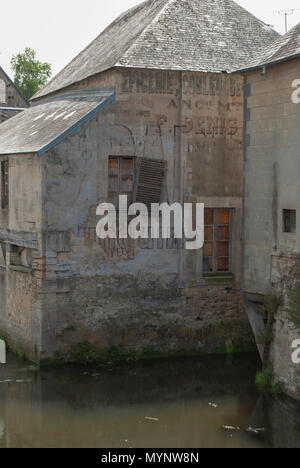 Alte französische Gebäude mit bleibt der gemalten Advert reminiscint von WW2 Blick auf die historischen Gebäude in Bayeaux, Normany, Frankreich Stockfoto