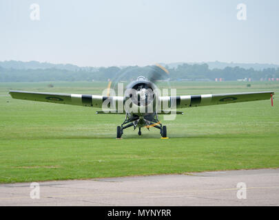 Oldtimer-Militärflugzeug mit drehendem Propeller auf dem Flugplatz der IWM Duxford, Cambridgeshire, Großbritannien, während eines historischen Flugturniers oder einer Ausstellung Stockfoto