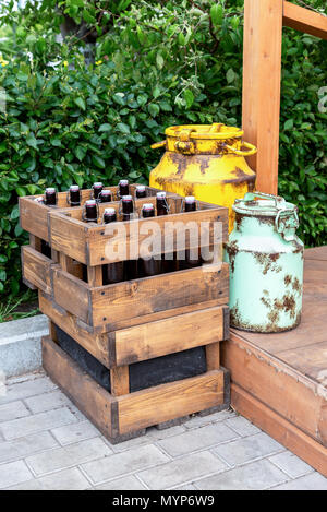 Vintage Holzkisten mit Handwerk Bier Flaschen und Dosen aus Metall stehen im Freien Stockfoto