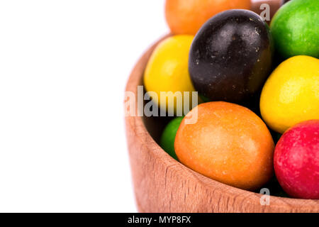 Ein Haufen von bunten Bonbons Erdnüsse in Schokolade in eine hölzerne Schüssel closeup Stockfoto