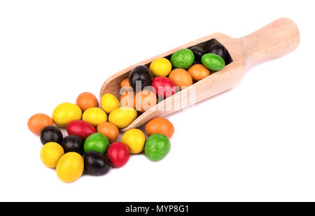 Ein Haufen von bunten Bonbons Erdnüsse in Schokolade in eine hölzerne Schaufel auf weißem Hintergrund Stockfoto