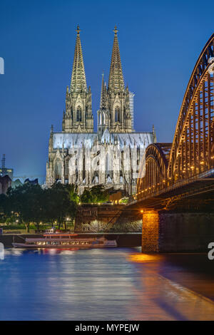 Den berühmten Kölner Dom und die Hohenzollern Eisenbahnbrücke in der Dämmerung Stockfoto