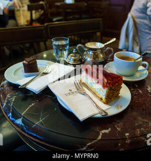 Wien, Österreich - Oktober 22, 2017: Auf dem Tisch des berühmten Konditorei cafe Demel Es gibt Kirschtorte, mini Sachertorte und Kaffeebecher mit Es Stockfoto