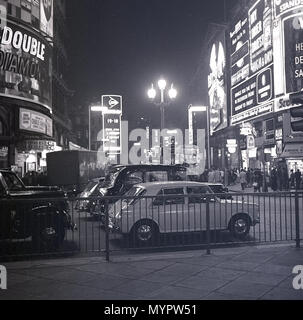 1960s, piccadilly Circus at Night, london, england, mit den berühmten Neon-Werbetafeln, die an der Kreuzung der Shaftesbury Avenue mit Taxis und dem Autoverkehr beleuchtet sind. Die Straße und der öffentliche Raum wurden 1819 gebaut, um Piccadilly mit der Regent Street zu verbinden und ist ein wichtiges Touristenziel im West End der Stadt. Stockfoto