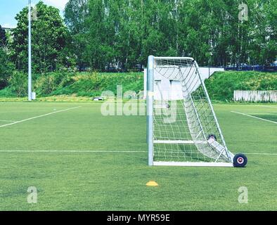 Die Fußball-Ziel im Sommer. Leer Ausbildung Tor für klassische fotbal auf grünem Gras Spielplatz. Bäume rund um das Stadion Stockfoto