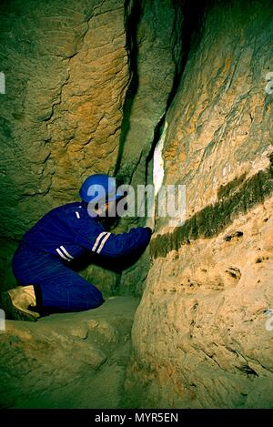 Workerman mit Helm und Schutzanzug mit glowes und Kopflampe. Man Jobs in der alten Grube Ventilation Welle. U-Arbeiter. Stockfoto