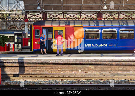 East Midlands Trains warten in Crewe station mit weiblichen Guard auf der Plattform Stockfoto