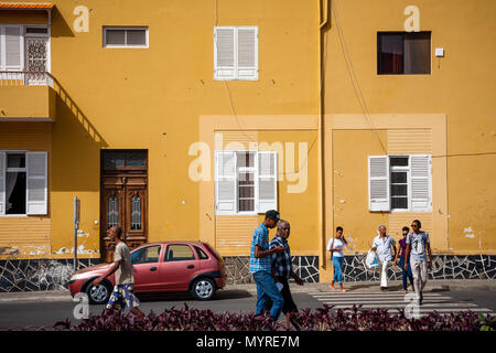 Leben in Mindelo, Bewohner auf den Straßen. Stadt Architektur, Große gelbe Wand MINDELO, KAP VERDE - 07. Dezember 2015 Stockfoto
