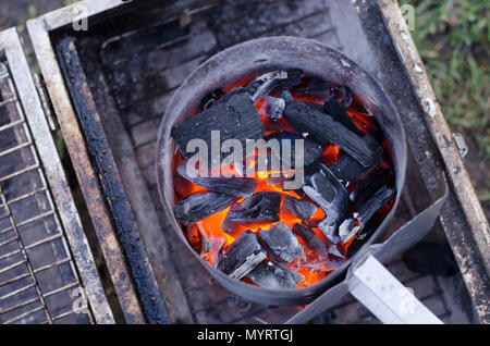 Ein Schornstein Starter im Einsatz die Holzkohle für den Grill in umweltfreundlicher Weise zu erhalten. Stockfoto