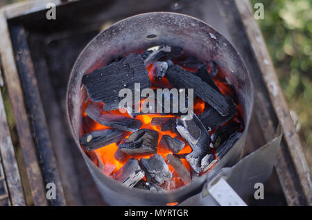 Ein Schornstein Starter im Einsatz die Holzkohle für den Grill in umweltfreundlicher Weise zu erhalten. Stockfoto