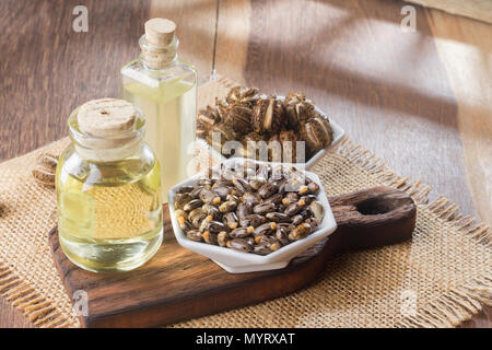 Samen und Rizinusöl auf dem Holztisch - Ricinus communis Stockfoto