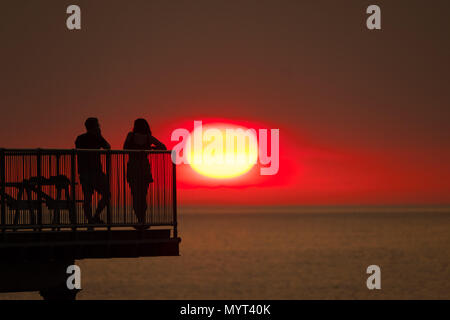 Aberystwyth Wales UK, Donnerstag, 07. Juni 2018 Deutschland Wetter: Der sehr heißen, sonnigen Sommer Sonnenschein weiter, wobei der Tag endet in einem herrlichen Sonnenuntergang über Leute pn am Meer Pier in Aberystwyth auf der Cardigan Bay Küste von West Wales Foto © Keith Morris/Alamy leben Nachrichten Stockfoto