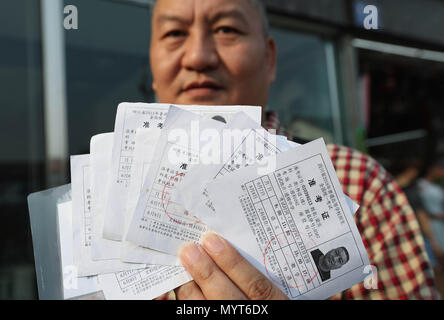 (180608) - CHENGDU, 8. Juni 2018 (Xinhua) - 51-jährige Liang Shi zeigt einige seiner Eintrittskarten für das College Aufnahmeprüfung in Chengdu, der Hauptstadt der Provinz Sichuan im Südwesten Chinas, 7. Juni 2018. Dieses Jahr ist es das 22. Mal für die 51-jährige Liang Shi für den nationalen College Aufnahmeprüfung sitzen. Liang begann seine Prüfung Reise 1983 und bestand darauf, für die nächsten fünf Jahre, sondern alle ausgefallenen Hochschulaufnahme Kerben zu erreichen. Er nahm sich der Prüfung im Jahr 2001, als China das Alter und die Ehe für die Prüfung abgebrochen. Obwohl sie nicht so viele Male, Liang hat nie aufgehört, Stockfoto