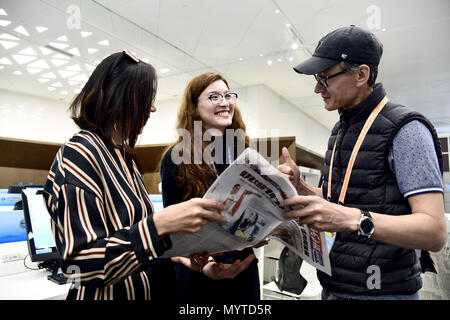 (180608) - Qingdao, 8. Juni 2018 (Xinhua) - Junusbekova Meruyert (C) Gespräche mit kasachischen Journalisten Darkeyev Yessim (R) an das Media Center des 18. Shanghai Cooperation Organisation (SCO) Gipfel in Qingdao, Osten Chinas Provinz Shandong, 8. Juni 2018. Meruyert von Almaty, Kasachstan hatte einen Traum von Studium und Leben in China. Nach einem Jahr Chinesisch lernen in der Shandong Universität für Technologie, sie wurde ein Student majoring in Petroleum Engineering an der China Universität für Erdöl im Jahr 2014. Als Mitarbeiter des 18. SCO-Gipfel, Meruyert bietet Dienstleistungen für Kasachische journalis Stockfoto