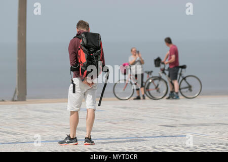 Blackpool, Lancashire. UKWeather. 08.06.2018. Hellen sonnigen Start in den Tag an der Küste wie Gebietsansässige, Urlauber, Ausflügler und Touristen machen Sie einen Spaziergang auf der Strandpromenade Attraktion, eine Komödie Pflaster oder Comedy Teppich auf der Promenade Tower Landspitze. Credit: MediaWorldImagesAlamyLiveNews. Stockfoto