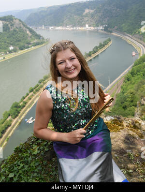 08. Juni 2018, Deutschland, St. Goarshausen: Tasmin Sophie Fetz, neue Vertreter der Loreley, kämmen die Haare während Ihrer Präsentation auf der weltberühmten Loreley Felsen über dem Rhein. Der 19-jährige Gymnasiast aus Doerscheid im Rhein Lahn Kreis ist die 17 Botschafter der Loreley und der Oberen Mittelrheintal (Mittelrheintal) Weltkulturerbe. Das felsplateau ist der Inbegriff der Rheinromantik und Hotspot der Tag Tourismus. Foto: Arne Dedert/dpa Stockfoto