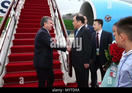 (180608) - Qingdao, 8. Juni 2018 (Xinhua) - usbekischen Präsidenten Shavkat Mirziyoyev (1. L) ist bei seiner Ankunft in Qingdao begrüßt, der ostchinesischen Provinz Shandong, 8. Juni 2018. Mirziyoyev ist hier zu besuchen, die bevorstehende 18. Sitzung des Rates der Regierungschefs der Mitgliedsstaaten der Shanghaier Organisation für Zusammenarbeit (SCO). (Xinhua / Zhang Cheng) (lx) Stockfoto