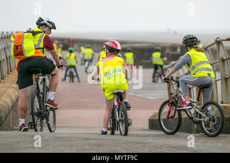 Sky Ride geführte Fahrten und Fahrradschulungen in Blackpool, Großbritannien. Diese Gruppen von Kindern tragen reflektierende Kleidung Kinderlehrer, oft etwa 20 Personen, fahren mit einem British Cycling Ride Leader, einem gut ausgebildeten und erfahrenen Fahrer, der die Kinder auf einer speziell ausgewählten Route führt, oft im Gelände, um Selbstvertrauen und Spaß auf dem Fahrrad zu schaffen. Stockfoto