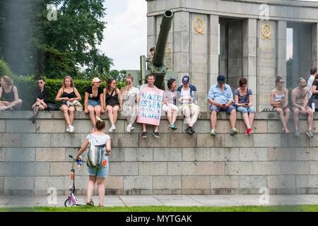 Berlin, Deutschland - März 2018: Gruppe von Demonstranten sitzen auf der Mauer in Berlin, der mit dem Motto "Nazis heimlich Essen, Falafel" (deutsch: Nazis Stockfoto