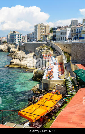 Restaurants am Strand an der Küste zwischen dem Meer und der Corniche Kennedy hängen haben ihre Terrassen mit Tischen, Sonnenschirmen und Liegestühlen auf einem h Stockfoto