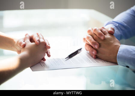 In der Nähe von zwei Geschäftsleute, die Hand mit dem Dokument auf Schreibtisch Stockfoto