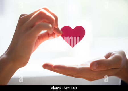 In der Nähe von Frau mit roten Herzen auf der Hand Stockfoto