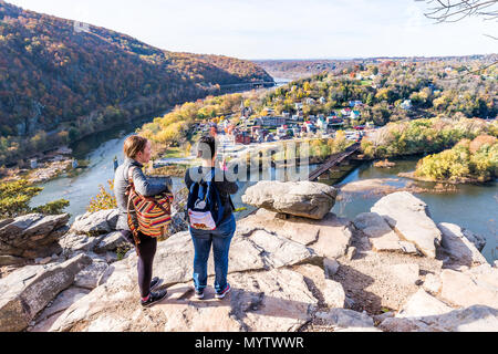 Harper's Ferry, USA - November 11, 2017: Blicken Sie mit Wanderer Leute, Paar, bunt orange gelb Laub Herbst Herbst Wald mit kleinen Dorf Stadt Stockfoto