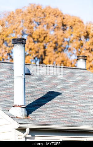 Vertikale Nahaufnahme von Haus Schindeln auf dem Dach Dach mit Kamin, Herbst orange gelb golden Blatt Blätter am Baum im Hintergrund Stockfoto